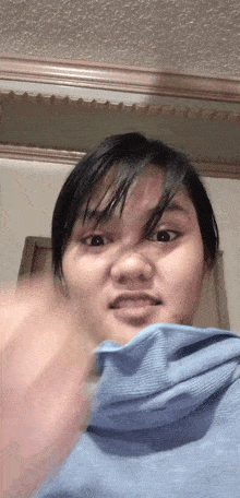 a woman in a blue shirt is making a face