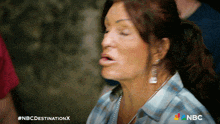 a woman with her eyes closed and a nbc logo on the bottom of her shirt