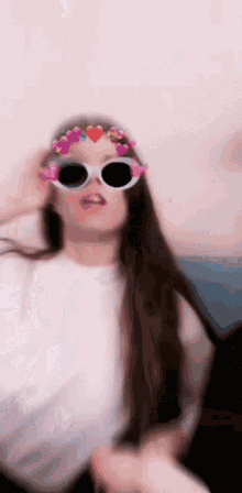 a woman wearing sunglasses with hearts on them is making a funny face