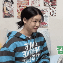 a girl wearing a blue and black striped hoodie with the word justice on the front