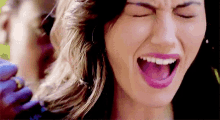 a close up of a woman 's face with her mouth open and her eyes closed .