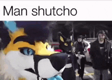 a man in a furry costume is walking down a street with a group of people .