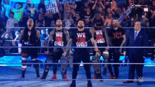 a group of wrestlers wearing shirts that say we the ones are standing in a ring