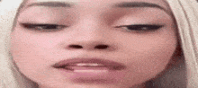 a close up of a woman 's face with her eyes closed and a pink lip .
