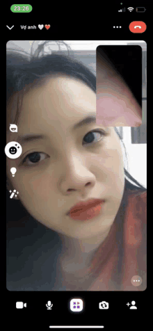 a phone screen shows a woman 's face and says 23:26 on the top left