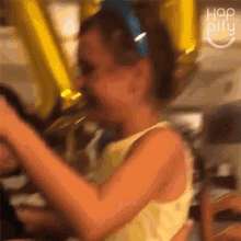 a woman in a yellow tank top is holding a yellow balloon with the number 7 on it
