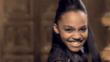 a young woman in a black leather jacket is smiling