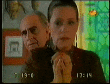 a woman is holding a knife in front of a man with blood on his face and the time is 17:14