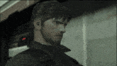 a man with a beard in a video game with a red light behind him