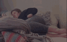 a woman is laying on a bed with her head on a pillow .