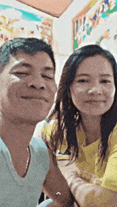 a man and a woman are posing for a picture and the woman is wearing a yellow shirt that says i love you