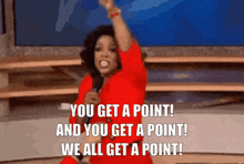 a woman in a red dress is holding a microphone and saying " you get a point "