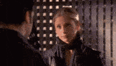 a man and a woman are standing next to each other in a dark room .