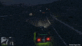 a car is driving down a dark street at night .