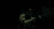 a man in a tank top is holding a rifle