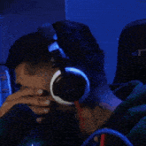 a man with a beard is wearing headphones and covering his mouth .