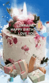 a birthday cake with flowers and gifts and a candle on top of it .