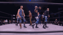 a group of wrestlers in a ring with the number 11 on their pants