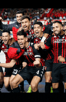 a group of soccer players wearing red and black uniforms with the number 23 on the front