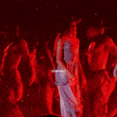 a woman in a cowboy hat is dancing with a group of people on stage .