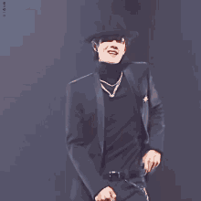 a man wearing a black hat and a black turtleneck sweater