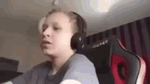 a young boy is wearing headphones and sitting in a chair .