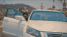 a man getting out of a white car with his door open