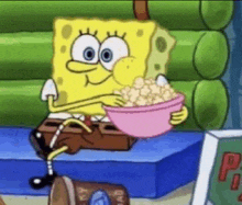 spongebob is sitting on a box eating popcorn from a pink bowl .