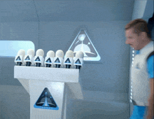 a man in a blue shirt stands in front of a podium with the word saturn on it