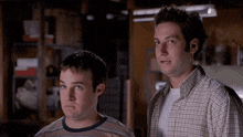 two men in plaid shirts are standing next to each other in a room