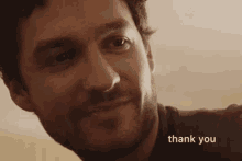 a close up of a man 's face with the words `` thank you '' written on the bottom .