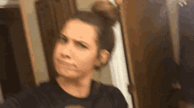 a woman is taking a selfie in front of a mirror while making a funny face .