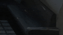 a girl with blue hair and a white shirt stands in a dark room