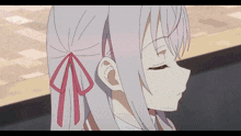 a girl with a red bow in her hair looks down