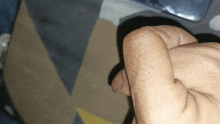 a close up of a person 's fist with a blue and yellow background