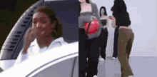 a woman is sitting in a car and a group of people are standing next to each other .