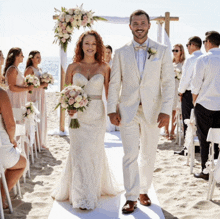a bride and groom are walking down the aisle at their beach wedding