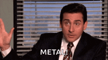a man in a suit and tie is sitting in front of a window with blinds and says `` metal '' .