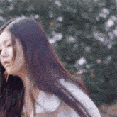 a woman with long hair is wearing a white shirt