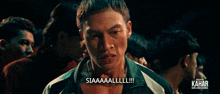 a group of young men are standing in a dark room and one of them says siaaaaalll !!!
