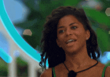 a woman in a green tank top is smiling