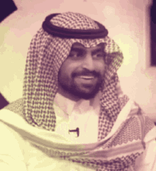 a man with a beard wearing a head scarf and a microphone on his neck