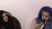 a woman with blue hair is smoking a bong