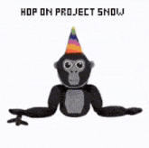 a stuffed gorilla wearing a party hat with the words `` hop on project show '' written above it .