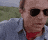 a man wearing sunglasses and a red scarf is saying `` that 's no puppy ! ''