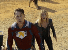 a man in a superhero costume is walking with a woman