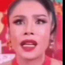 a close up of a woman 's face with a red shirt on