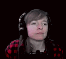 a woman wearing headphones is making a funny face and says dzien dobry .
