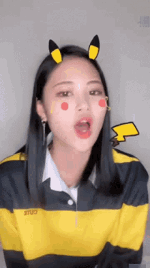 a girl wearing a yellow and black striped shirt with the word cole on the sleeve