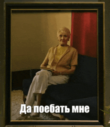 a framed picture of an elderly woman sitting on a couch with the caption да поебать мне in white letters